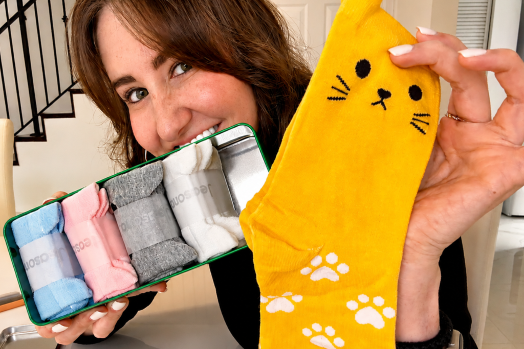 woman holds a set of cat socks