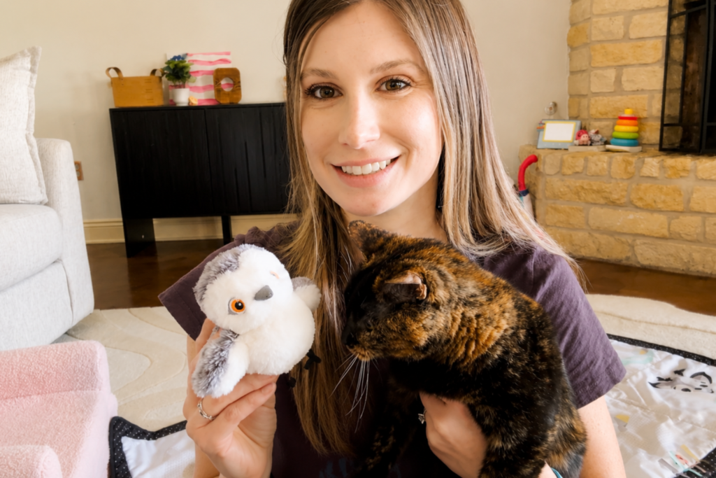 young woman holds cat and potaroma chirping bird toy